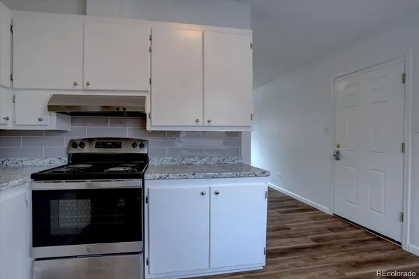 a kitchen with granite countertop cabinets and steel stove