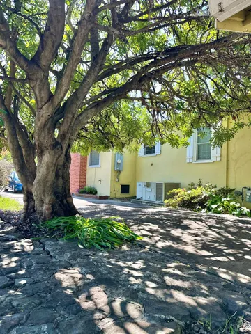 a view of a backyard with table and chairs and a large tree