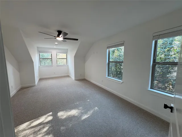 an empty room with windows and ceiling fan view