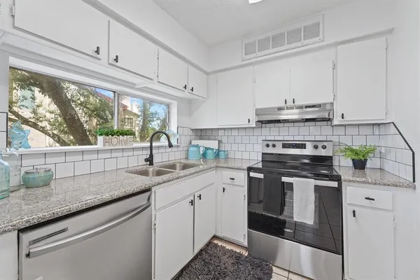 a kitchen with stainless steel appliances granite countertop a refrigerator sink and stove