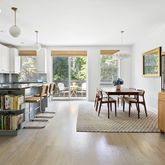 a living room with furniture a dining table and a large window