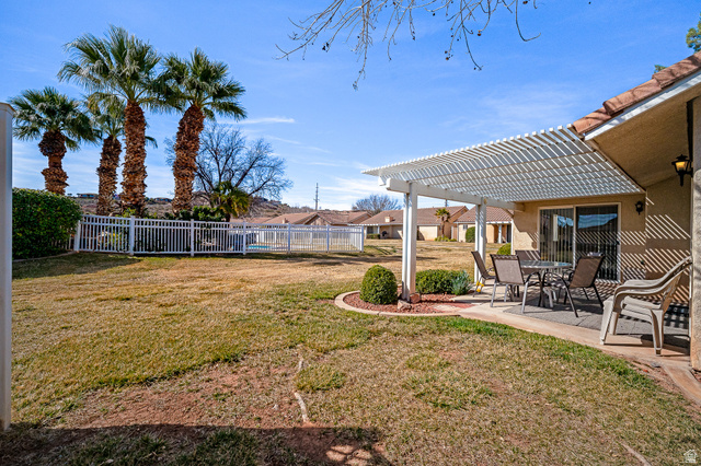 1825 West Mathis Park Place, Unit 46 St. George, UT 84770 - Photo 40 of 45 Fenced backyard featuring a patio area, a pergola, outdoor dining area, and a residential view