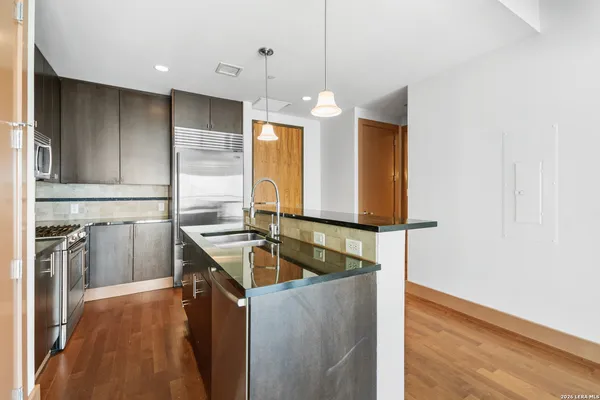 a kitchen with a refrigerator a sink and wooden floor