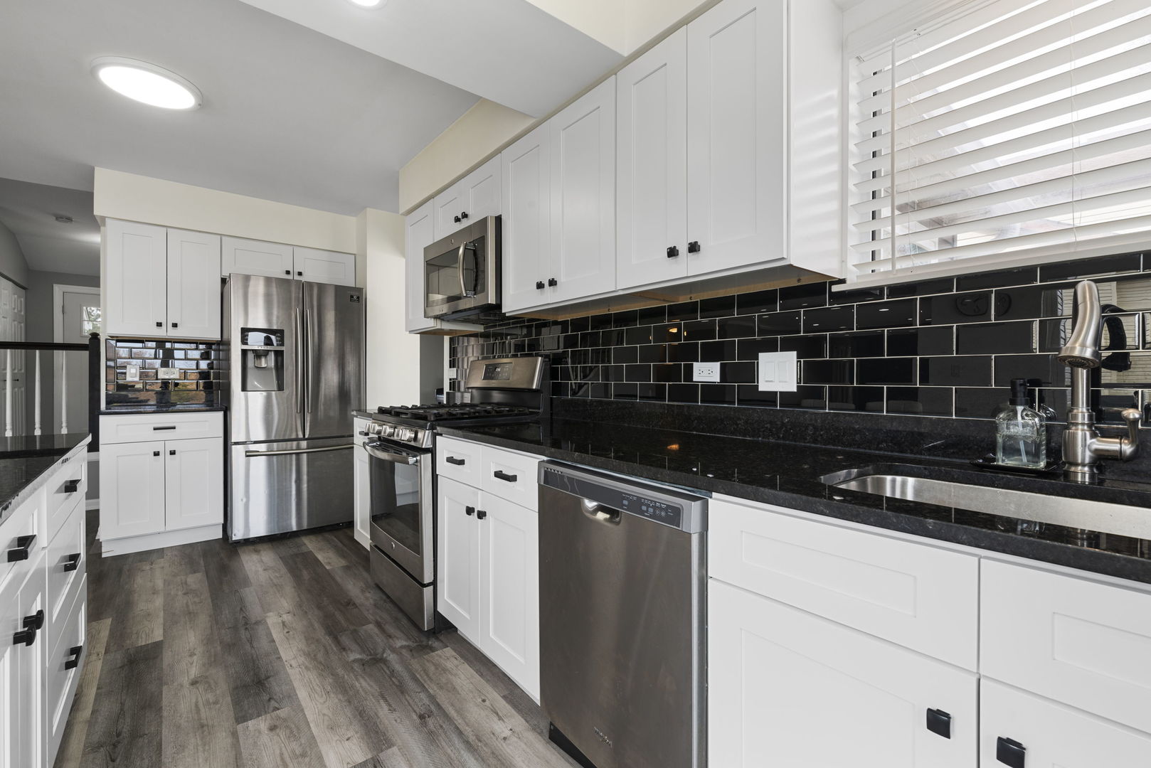 4599 Mumford Drive Hoffman Estates, IL 60192 - Photo 11 of 25 a kitchen with stainless steel appliances a refrigerator a sink and wooden cabinets