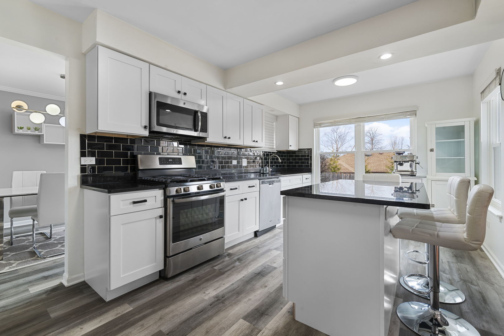 4599 Mumford Drive Hoffman Estates, IL 60192 - Photo 9 of 25 a kitchen with stainless steel appliances white cabinets a sink a stove a refrigerator and a microwave
