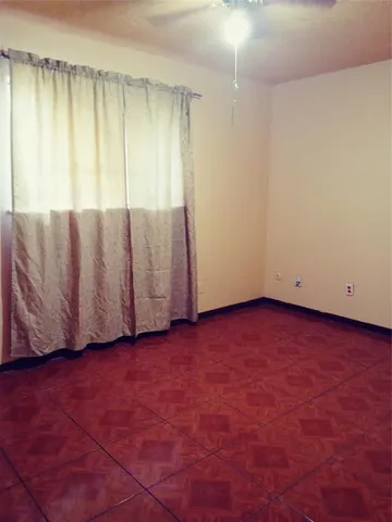 an empty room with a wooden floor and a window