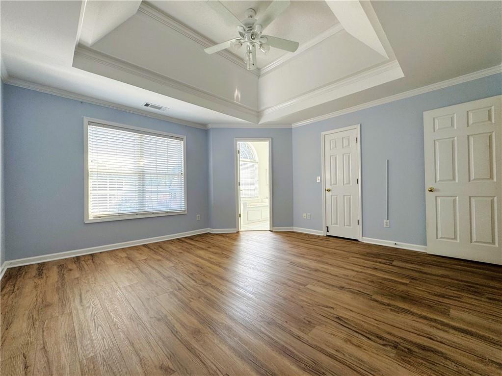 2075 Pine Tree Drive Buford, GA 30518 - Photo 11 of 18 an empty room with wooden floor chandelier fan and windows