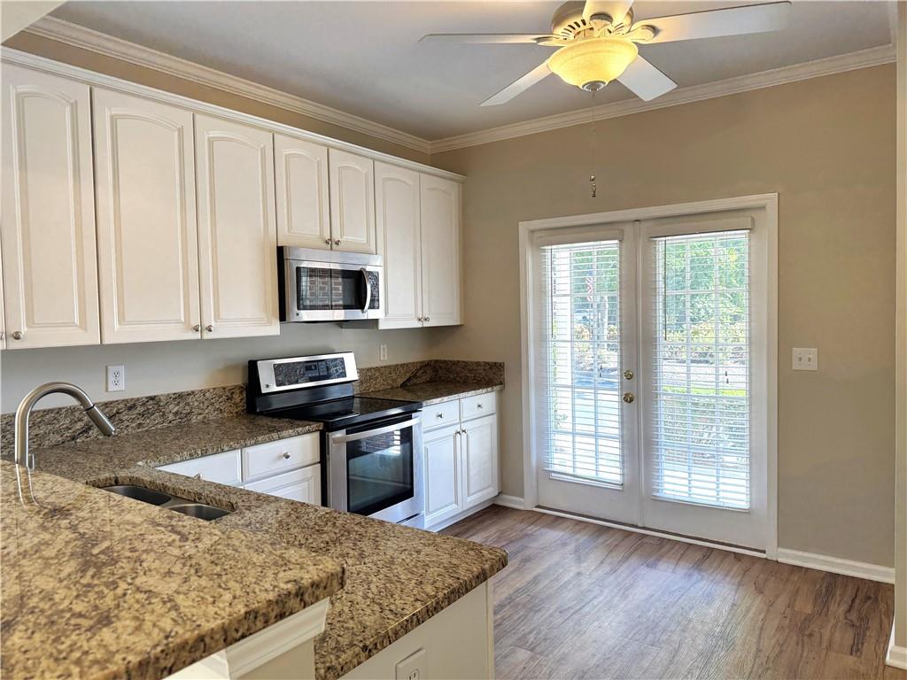 2075 Pine Tree Drive Buford, GA 30518 - Photo 8 of 18 a kitchen with granite countertop a stove a sink and a microwave
