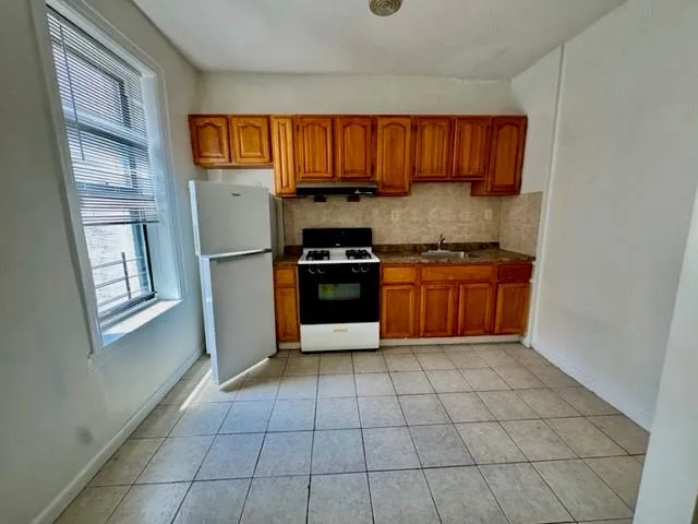 a kitchen with granite countertop a stove top oven and cabinets