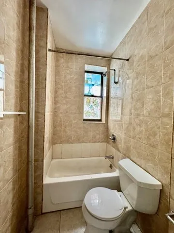 a bathroom with a toilet bathtub and shower