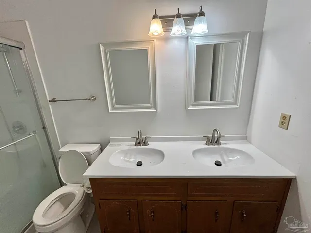 a bathroom with a granite countertop toilet and a shower