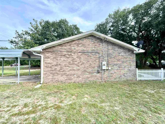 an empty room with wooden floor cabinet and windows