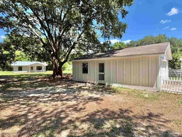 a view of a house with a tree in the background
