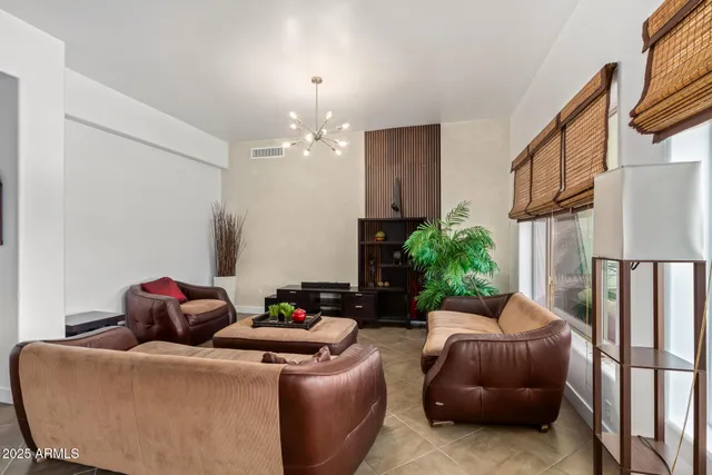 a living room with furniture flowerpot and a chandelier