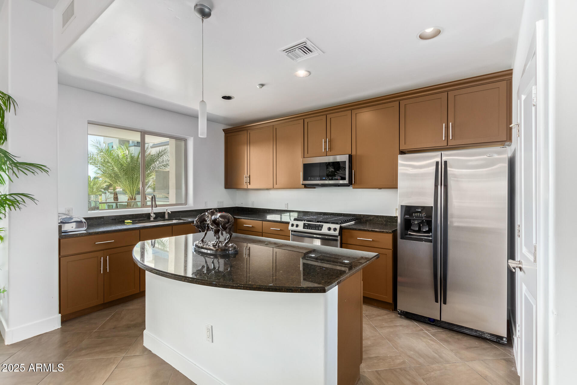 945 East Playa Del Norte Drive, Unit 3004 Tempe, AZ 85288 - Photo 7 of 41 a kitchen with kitchen island granite countertop a sink stove and refrigerator