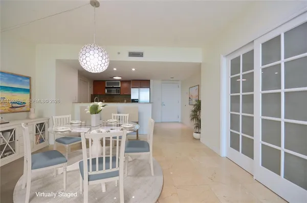 a view of a dining room and livingroom with furniture a rug a fireplace and a chandelier