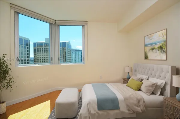 a bedroom with a bed and a large window