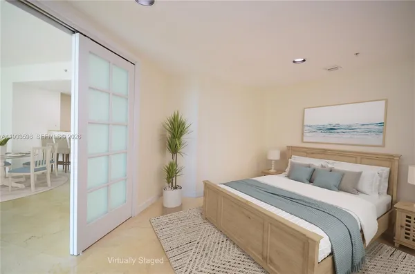 a bedroom with a large bed and a potted plant