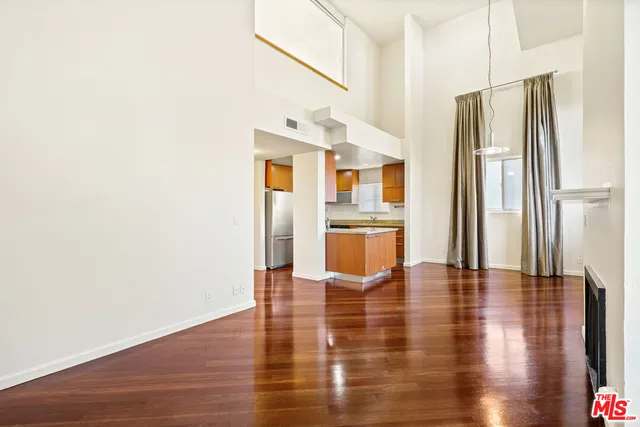 a view of kitchen with stainless steel appliances wooden floor and chair