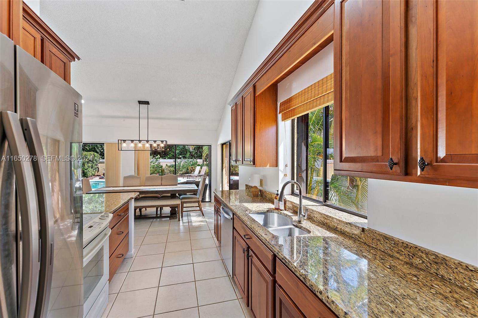 101 Sand Pine Drive, Unit 101 Jupiter, FL 33477 - Photo 11 of 47 a kitchen with stainless steel appliances a sink and a large window