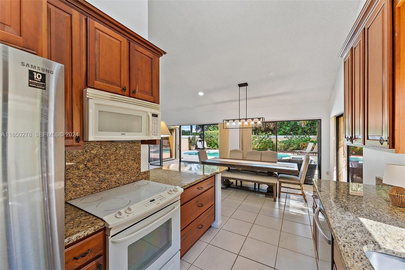 101 Sand Pine Drive, Unit 101 Jupiter, FL 33477 - Photo 12 of 47 a kitchen with a stove a sink and a refrigerator
