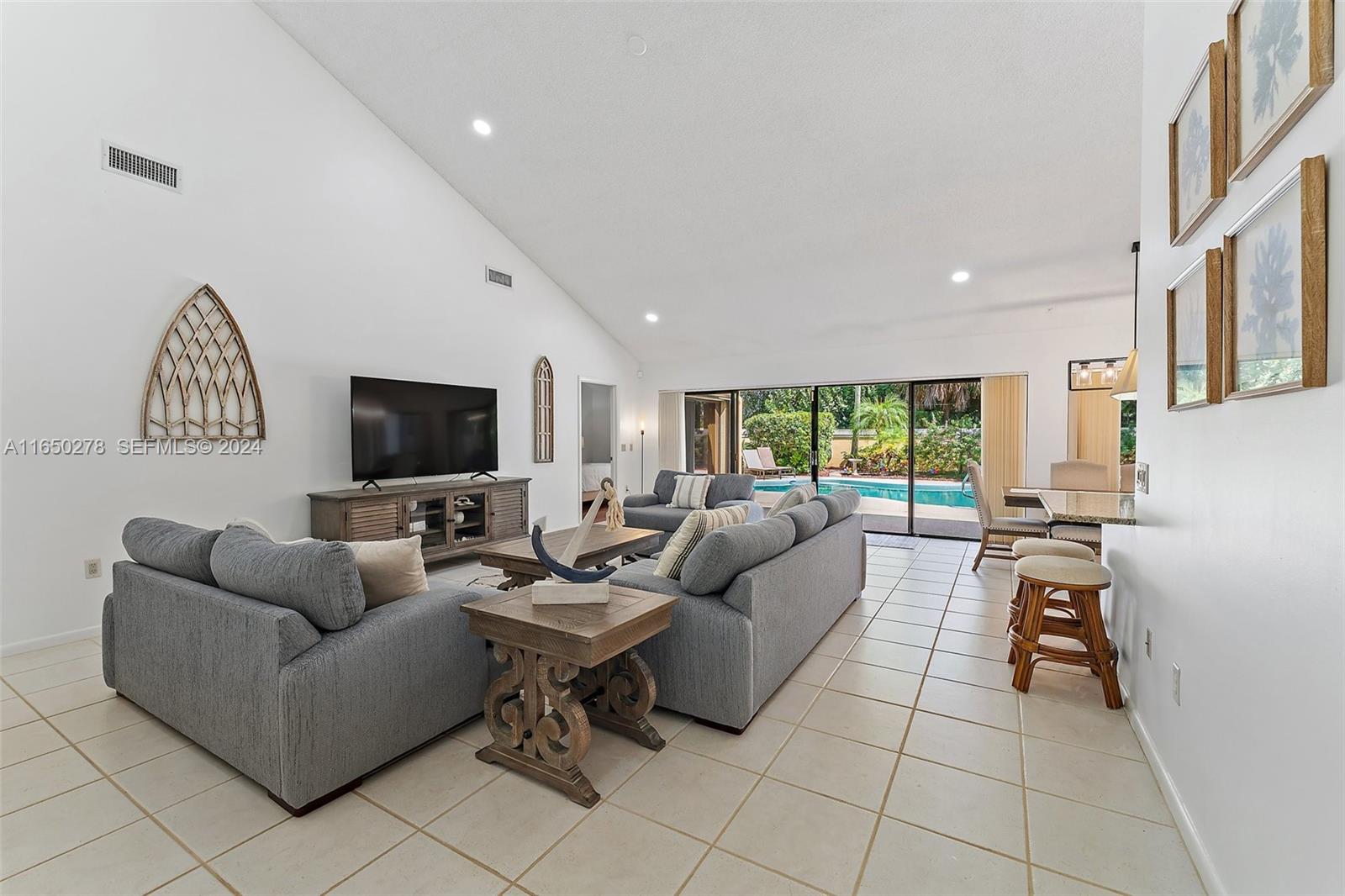 101 Sand Pine Drive, Unit 101 Jupiter, FL 33477 - Photo 17 of 47 a living room with furniture and a flat screen tv