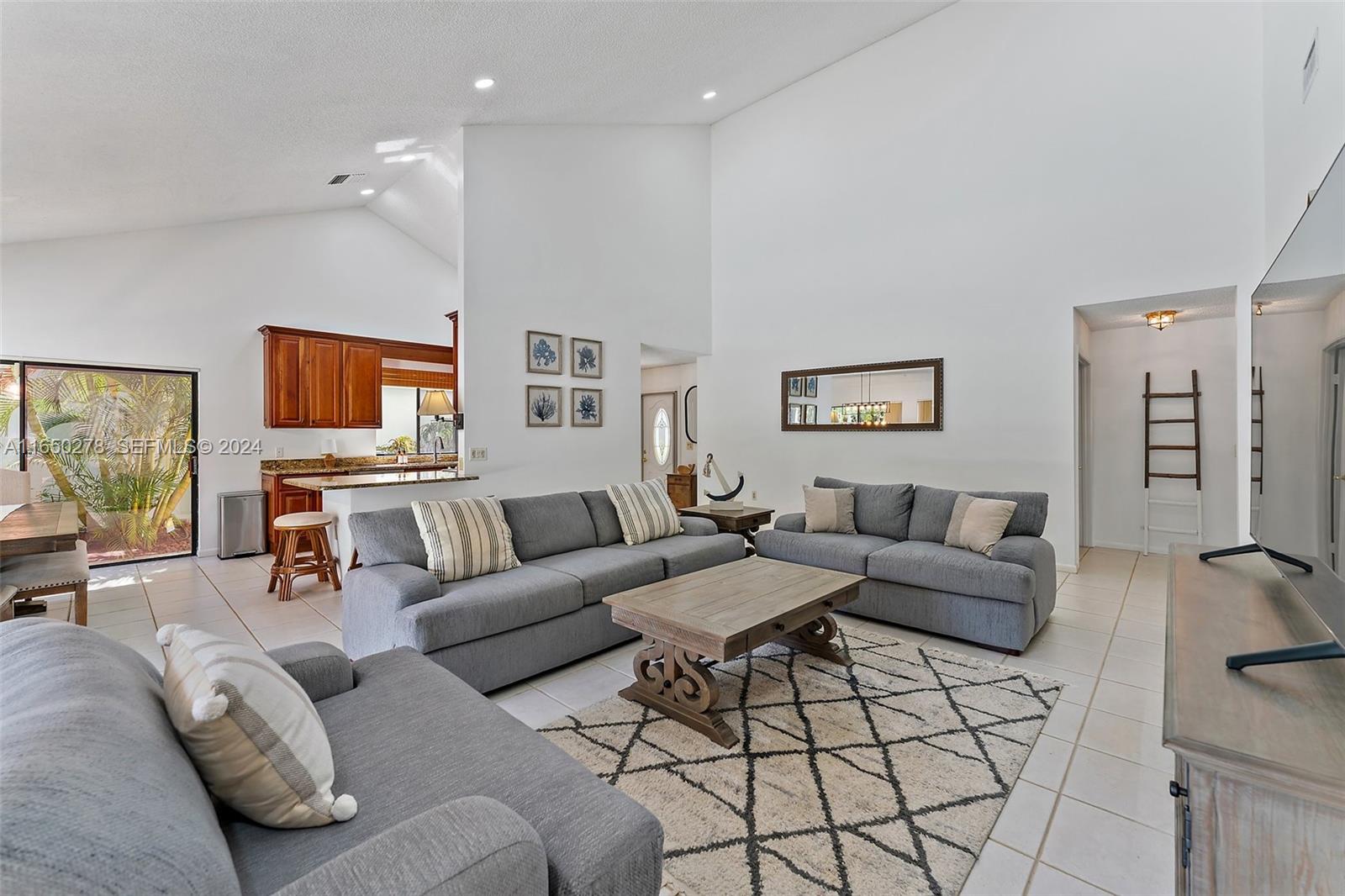 101 Sand Pine Drive, Unit 101 Jupiter, FL 33477 - Photo 20 of 47 a living room with furniture and a flat screen tv