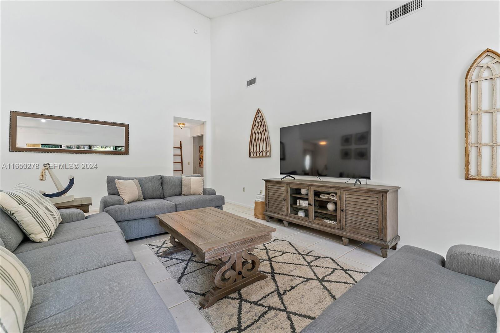 101 Sand Pine Drive, Unit 101 Jupiter, FL 33477 - Photo 23 of 47 a living room with furniture and a flat screen tv