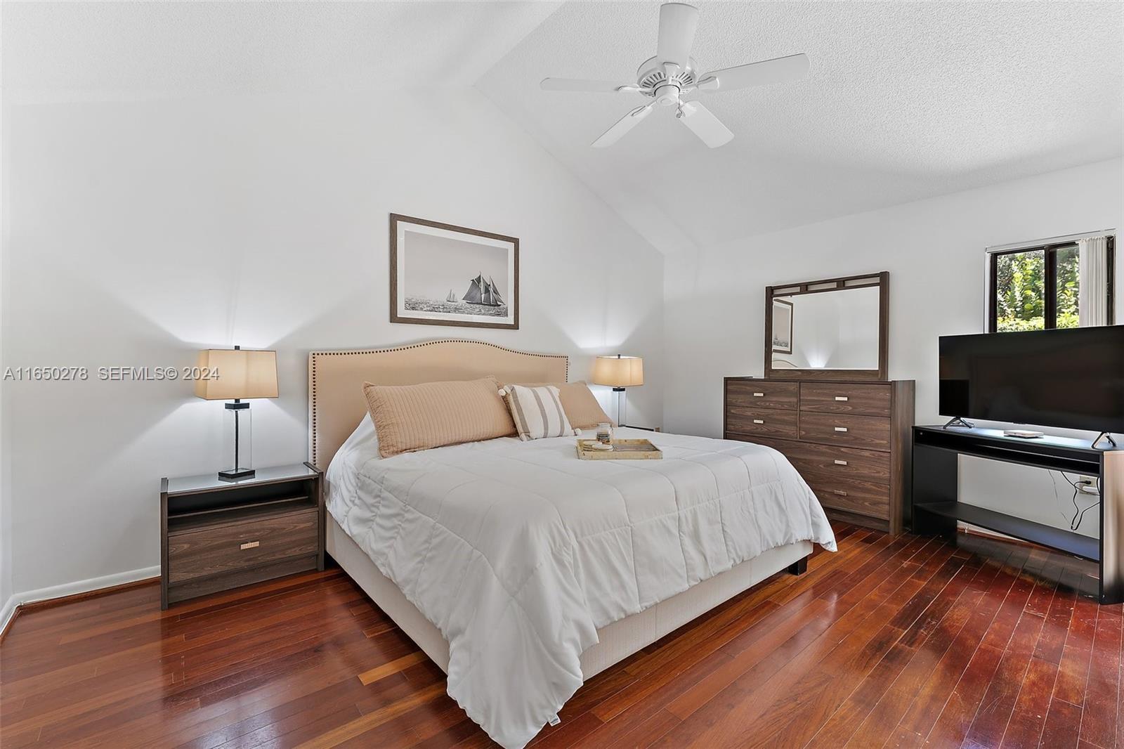 101 Sand Pine Drive, Unit 101 Jupiter, FL 33477 - Photo 24 of 47 a bedroom with a bed and a flat screen tv