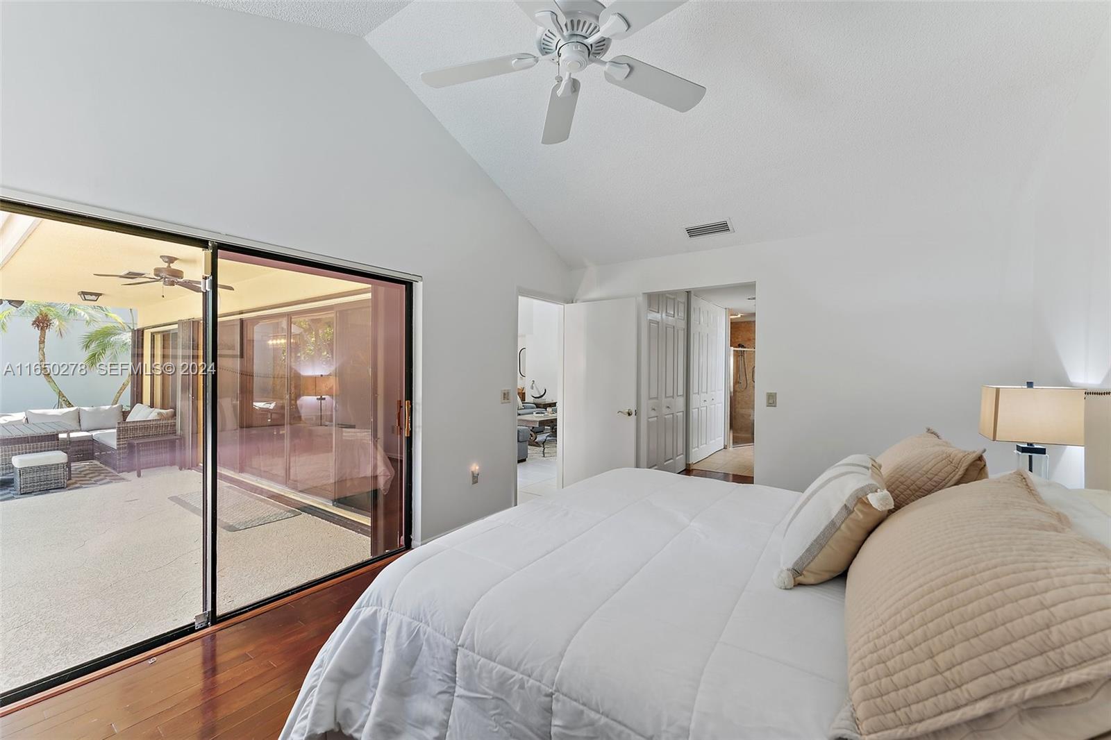 101 Sand Pine Drive, Unit 101 Jupiter, FL 33477 - Photo 26 of 47 a bedroom with a large bed and a chandelier