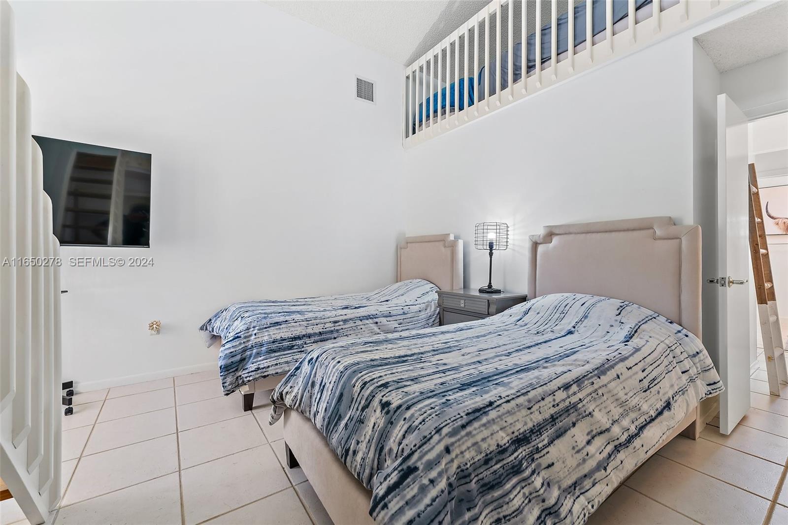 101 Sand Pine Drive, Unit 101 Jupiter, FL 33477 - Photo 32 of 47 a bedroom with a bed and a window