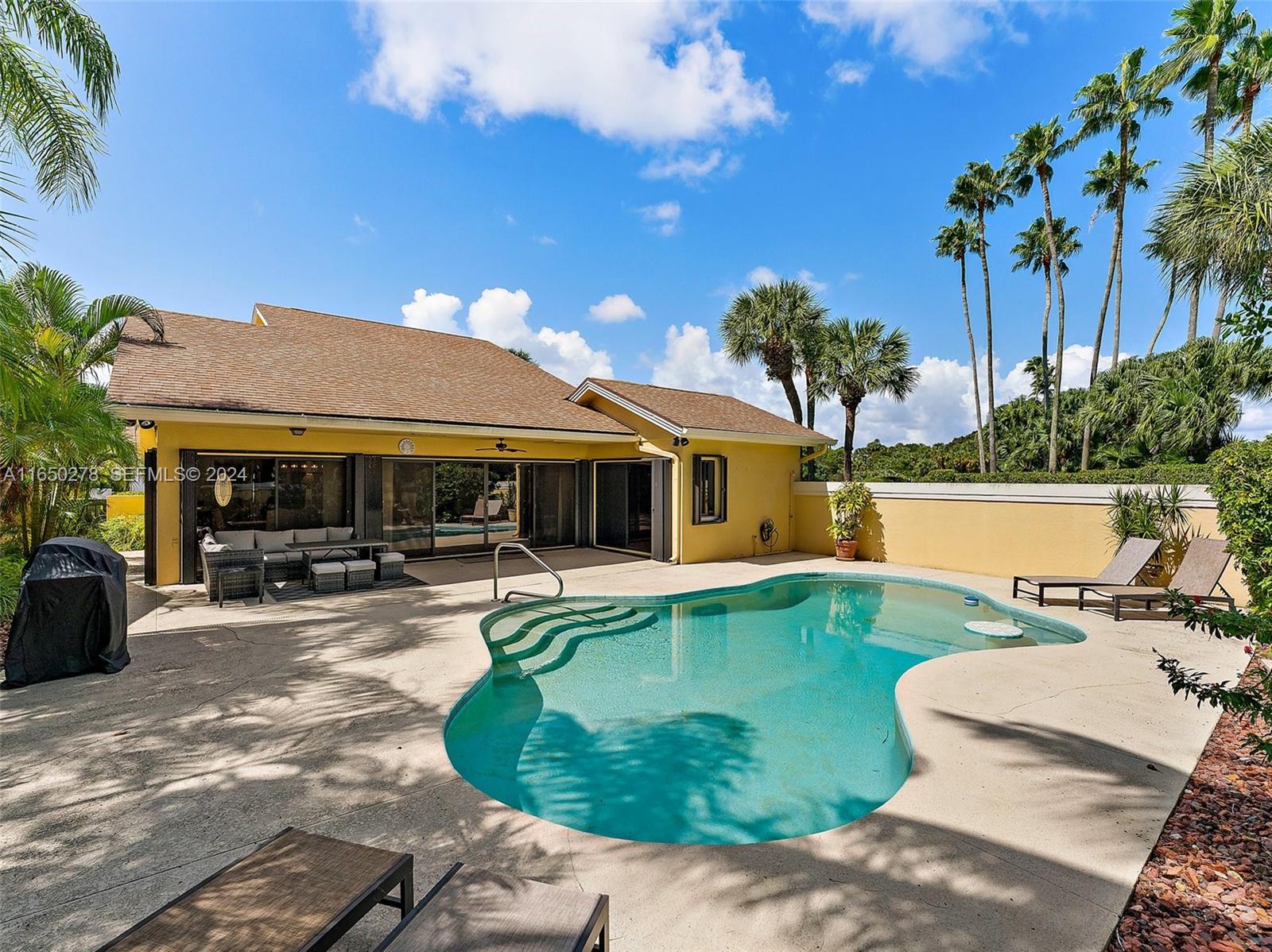 101 Sand Pine Drive, Unit 101 Jupiter, FL 33477 - Photo 42 of 47 a swimming pool with outdoor seating yard and barbeque oven