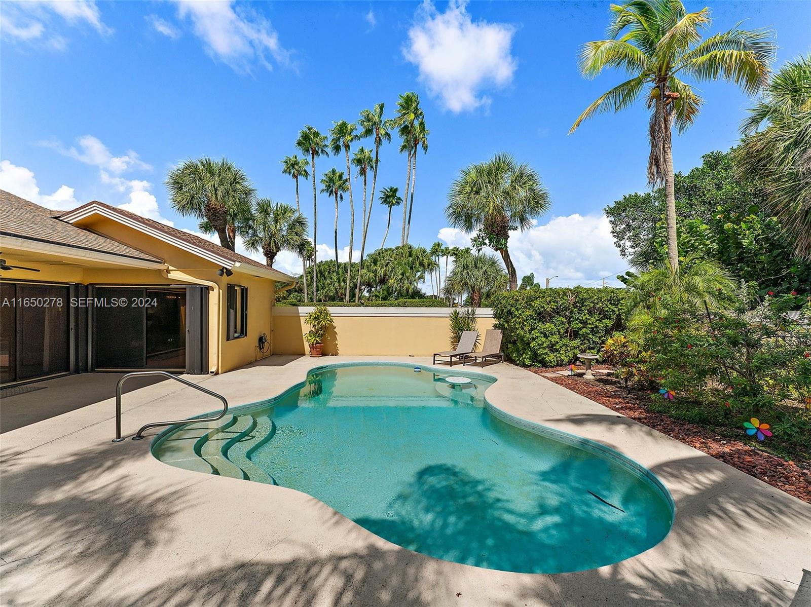 101 Sand Pine Drive, Unit 101 Jupiter, FL 33477 - Photo 43 of 47 a view of a house with a swimming pool and a porch