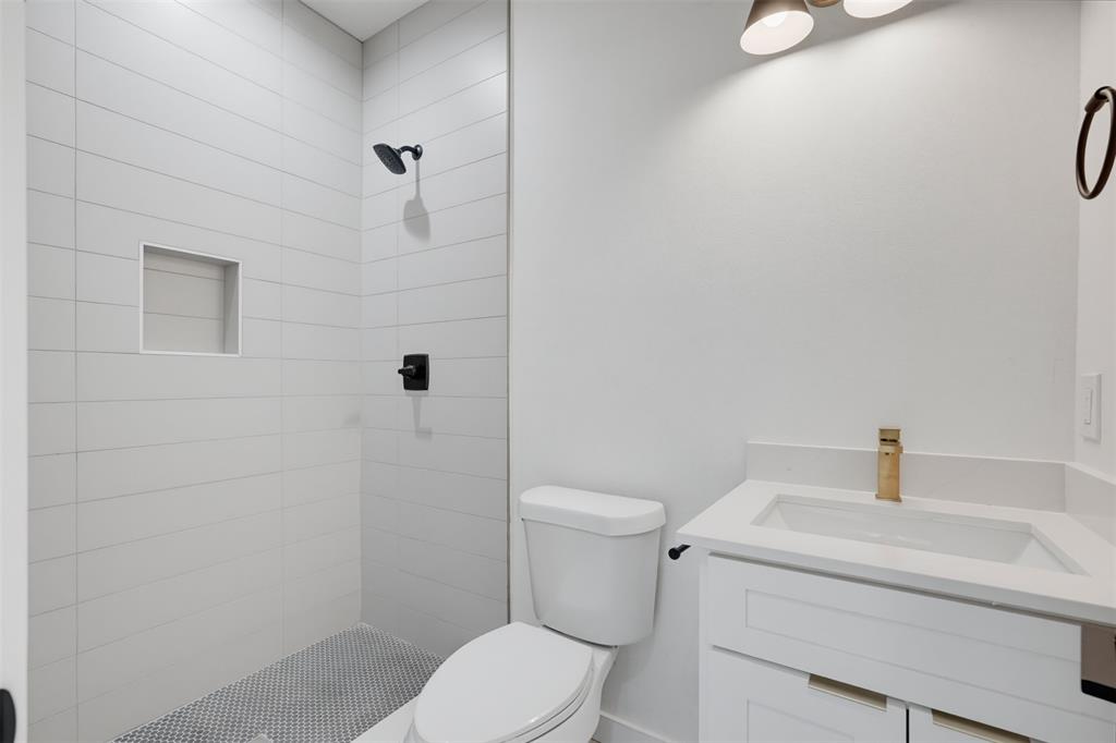 512 South O Connor Road Irving, TX 75060 - Photo 10 of 21 Bathroom featuring a walk-in shower with white subway-style tiling and a built-in niche