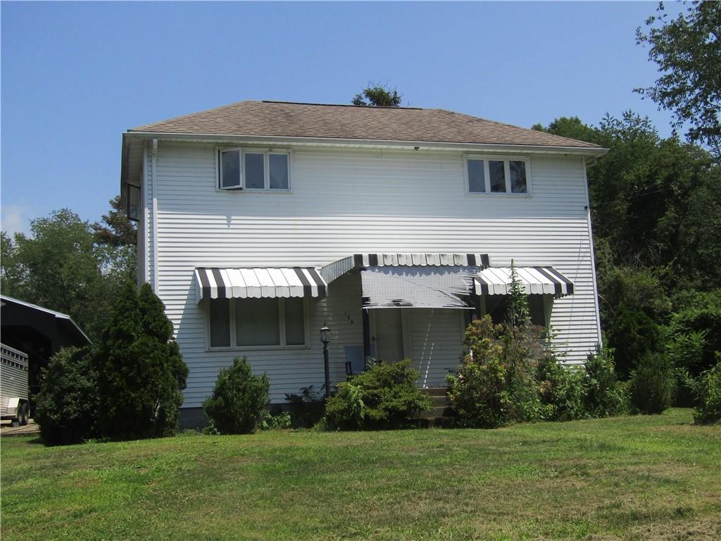 a front view of a house with a yard and potted plants