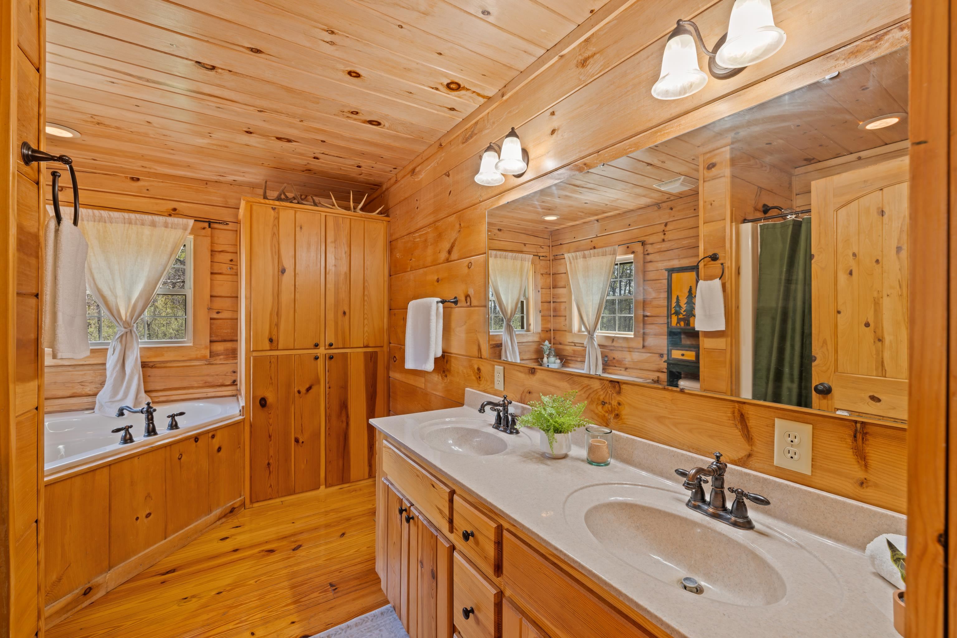 115 Spring Crossing Lane Steeles Tavern, VA 24476 - Photo 36 of 74 a spacious bathroom with a double vanity sink a large mirror and a bathtub