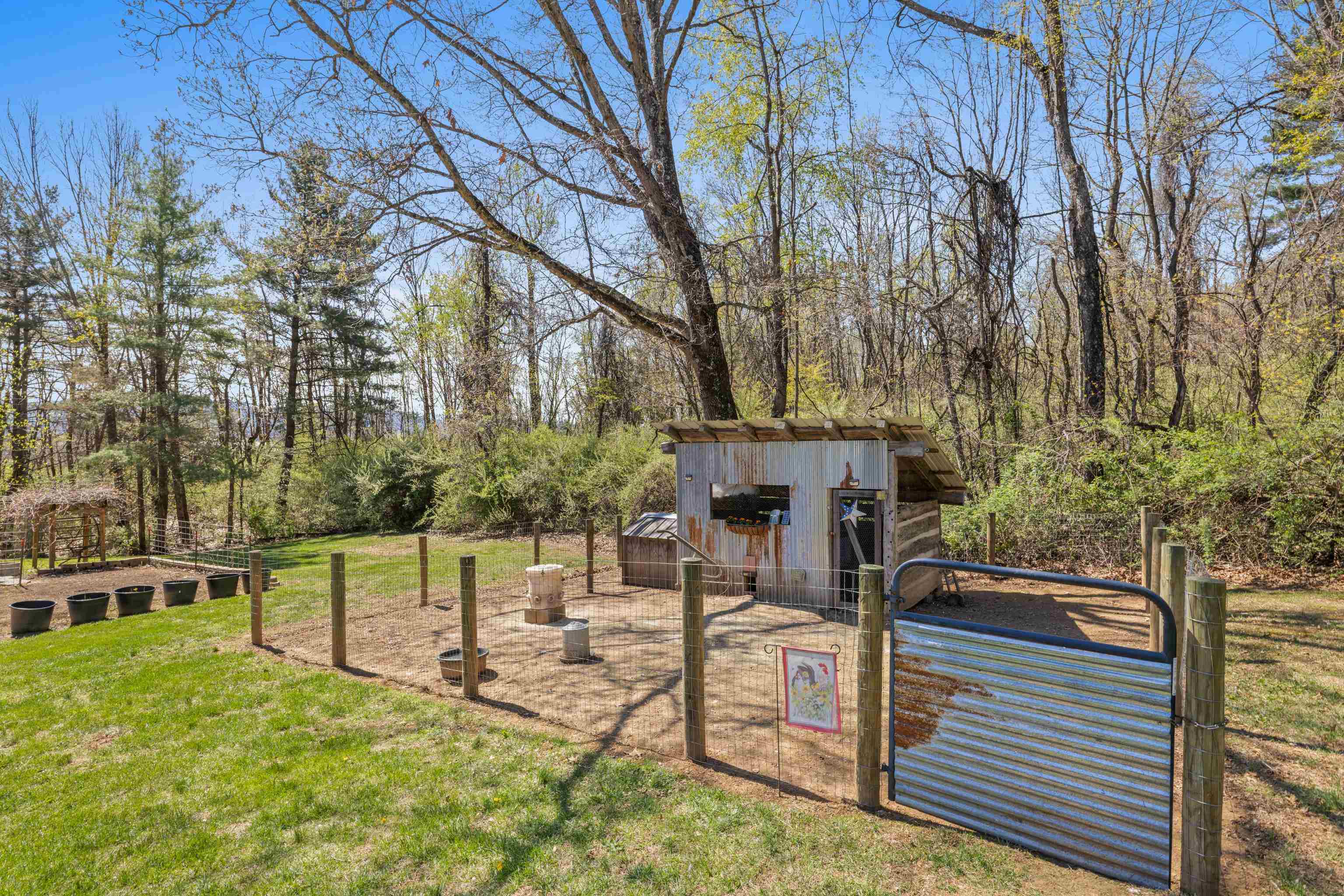 115 Spring Crossing Lane Steeles Tavern, VA 24476 - Photo 60 of 74 a view of a patio with table and chairs with wooden fence and plants