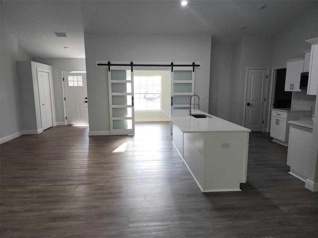 1111 Dagmar Avenue Spring Hill, FL 34606 - Photo 8 of 27 a view of a kitchen with wooden floor and electronic appliances