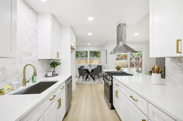 a kitchen with a stove and white cabinets