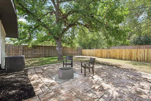 a view of a house with a yard and large tree