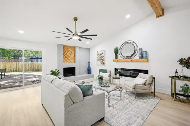 a living room with furniture a fireplace and a large window