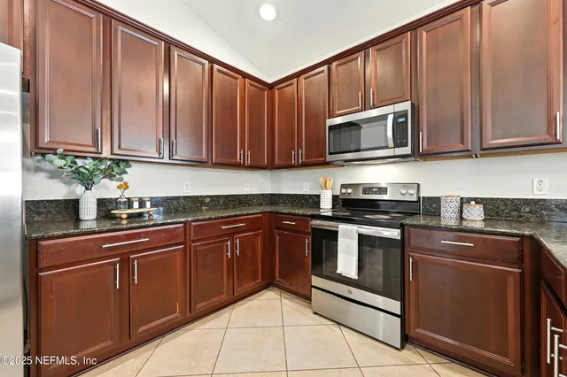 an aerial view of a house with a yard and mountain view
