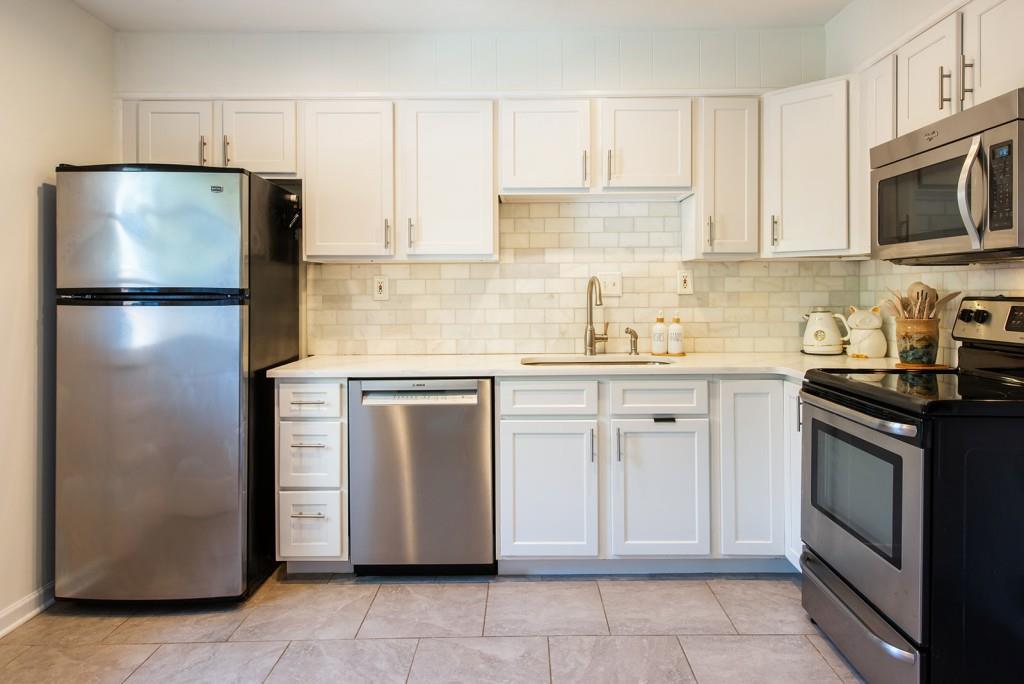 3 Surry County Place Northwest Atlanta, GA 30318 - Photo 11 of 50 a kitchen with stainless steel appliances granite countertop a refrigerator sink and stove