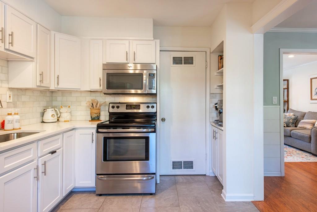 3 Surry County Place Northwest Atlanta, GA 30318 - Photo 12 of 50 a kitchen with cabinets stainless steel appliances and wooden floor