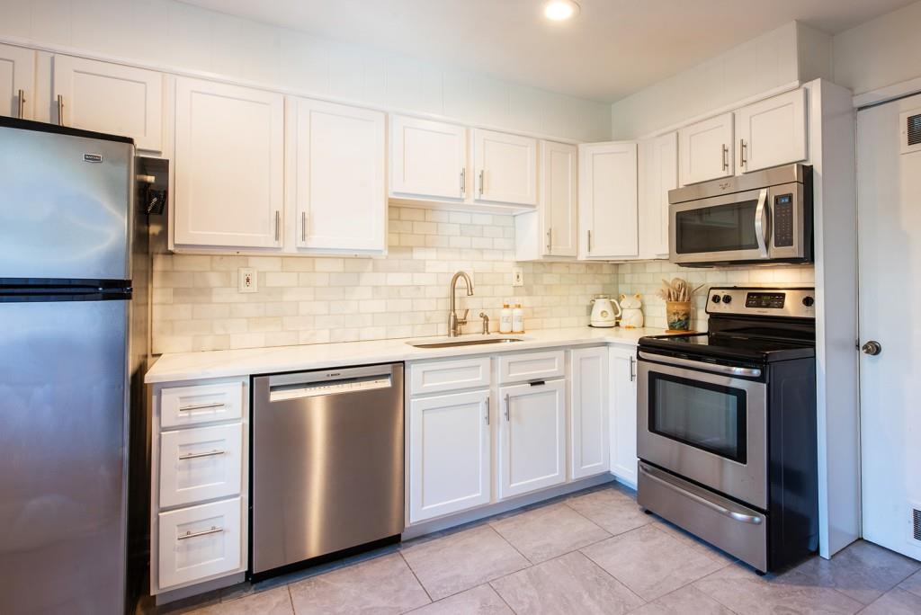 3 Surry County Place Northwest Atlanta, GA 30318 - Photo 13 of 50 a kitchen with cabinets stainless steel appliances and sink