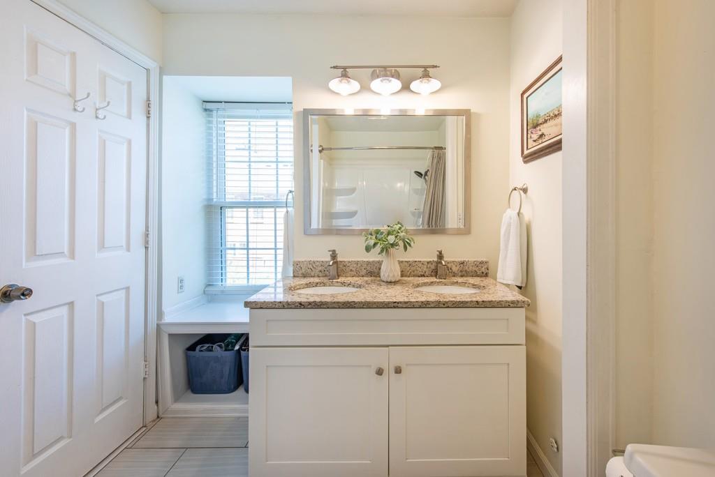 3 Surry County Place Northwest Atlanta, GA 30318 - Photo 23 of 50 a bathroom with a granite countertop sink a mirror and a vanity