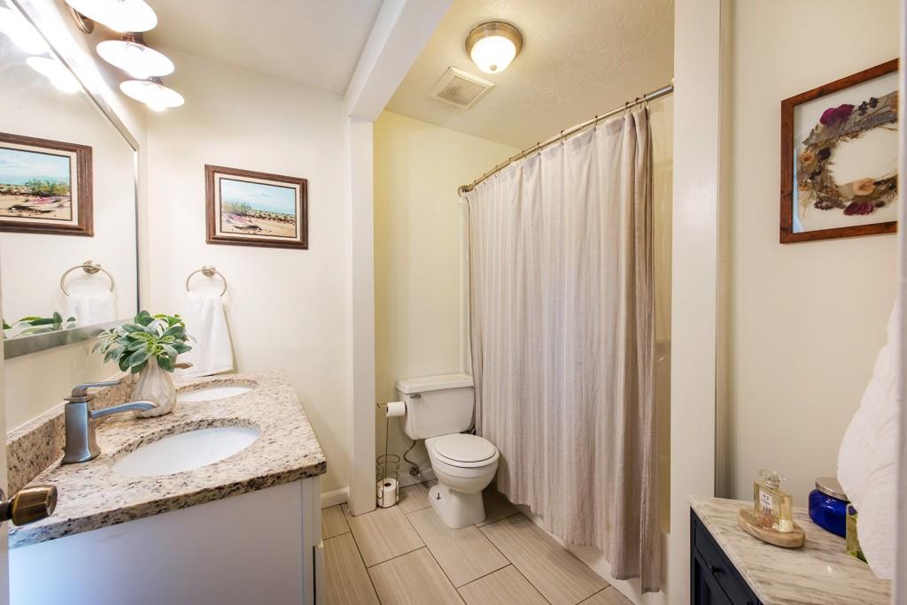 3 Surry County Place Northwest Atlanta, GA 30318 - Photo 24 of 50 a bathroom with a granite countertop sink a toilet and a large mirror