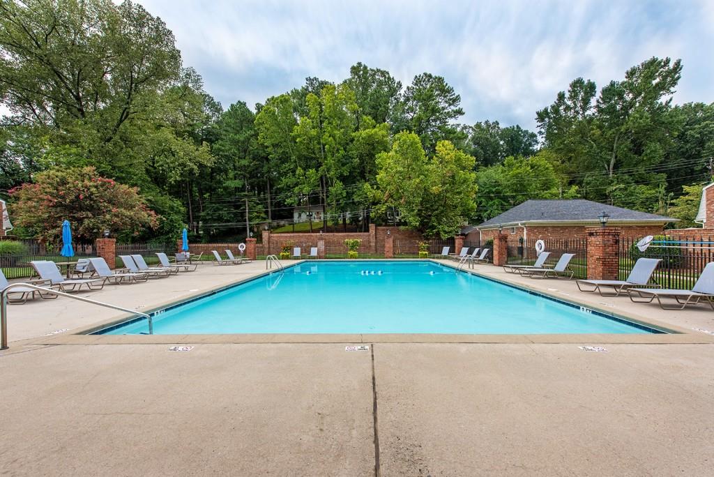 3 Surry County Place Northwest Atlanta, GA 30318 - Photo 45 of 50 a view of a swimming pool with lawn chairs under an umbrella