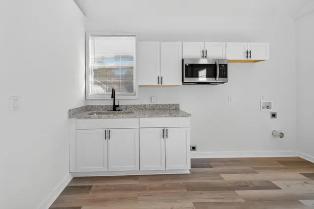 a kitchen with stainless steel appliances granite countertop a sink a stove and microwave