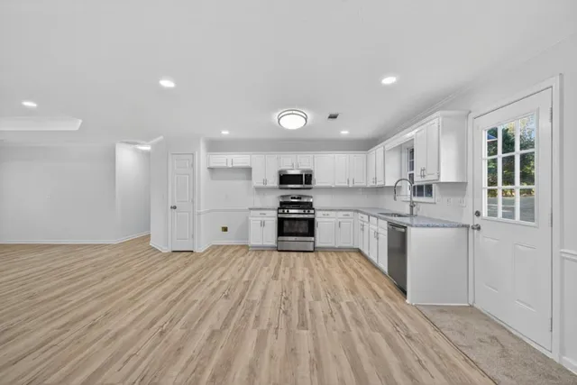 a kitchen with granite countertop a stove top oven sink and cabinets